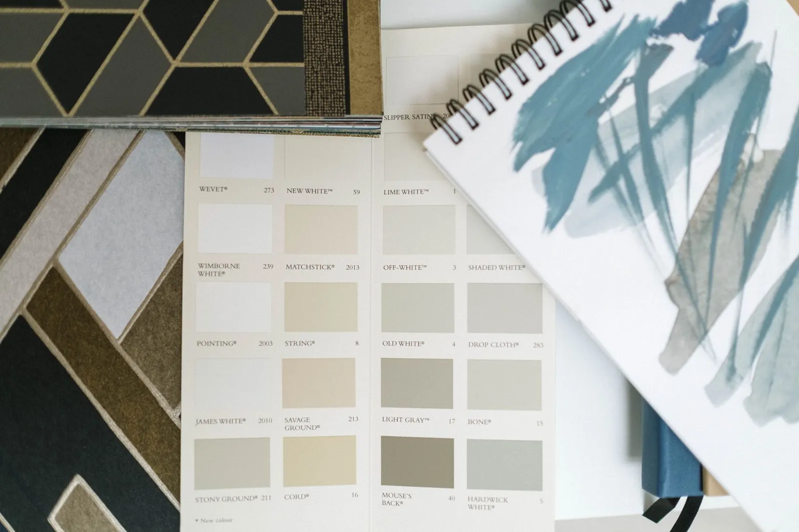Paint sample chips arranged by undertone showing cream, taupe, warm gray, and greige neutral options side by side