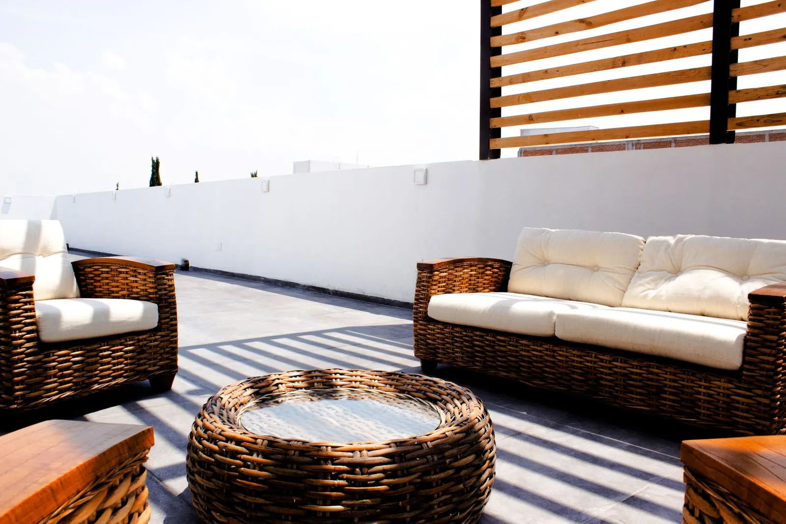 Teak outdoor dining set with honey-brown finish on a stone patio