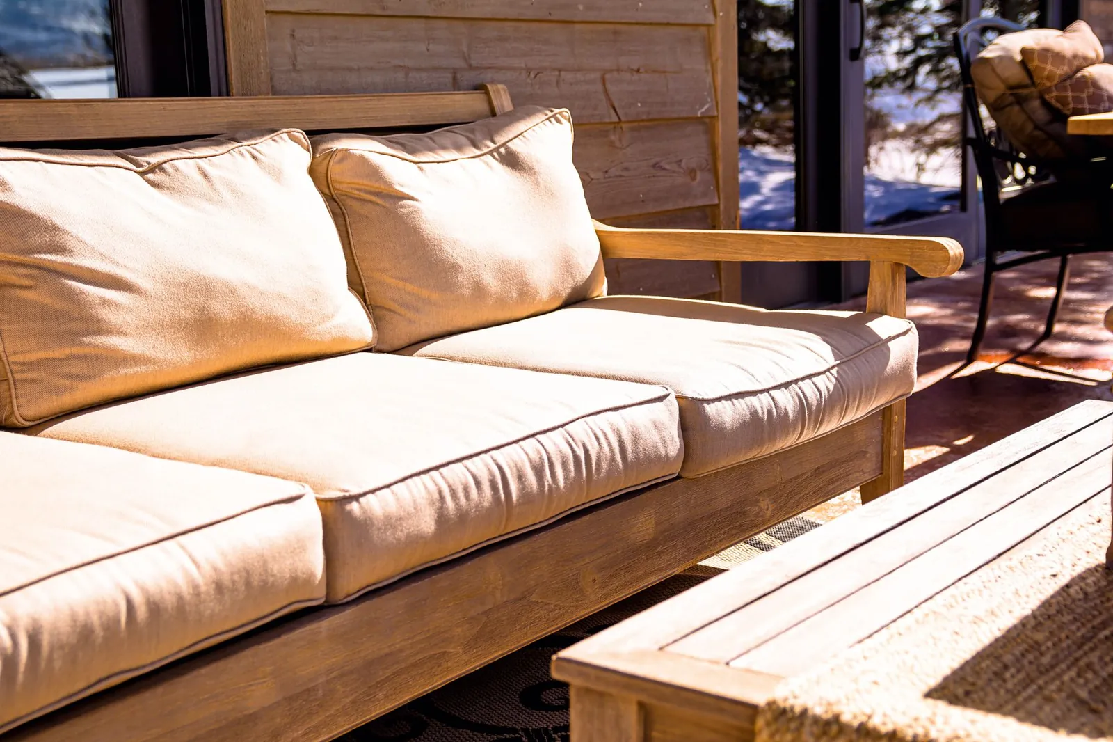 Resin wicker conversation set with cushions on a deck overlooking trees