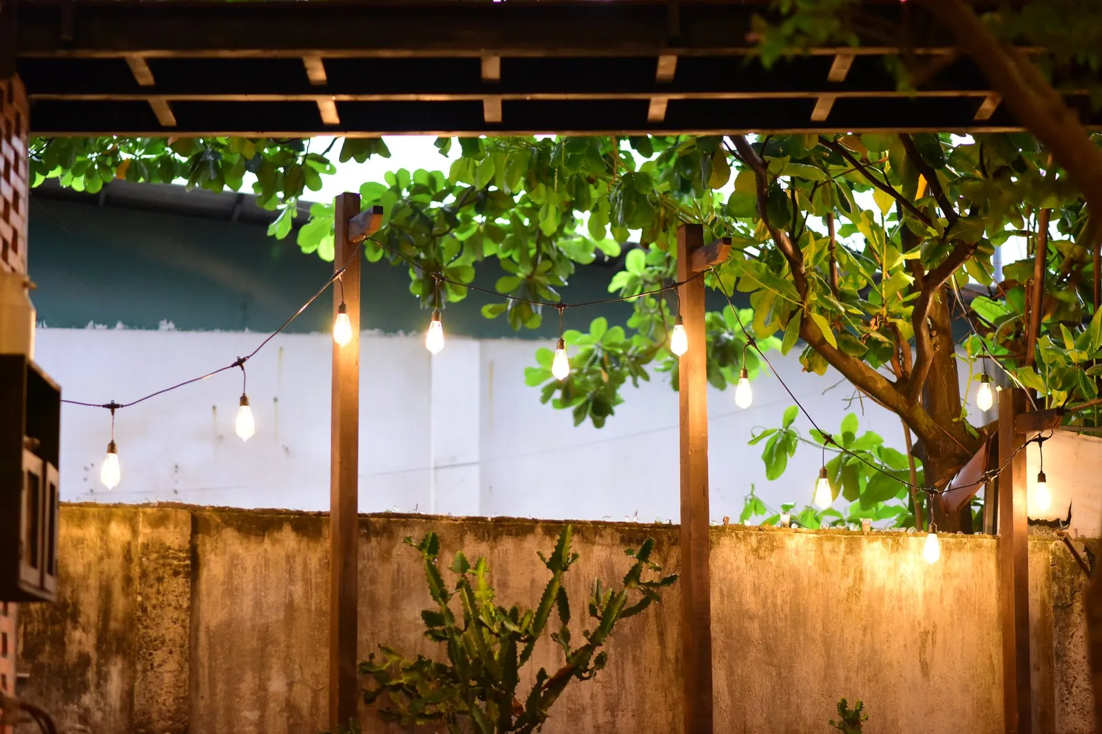 Low-voltage recessed LED lights spaced along a patio edge casting soft pools of light on stone pavers