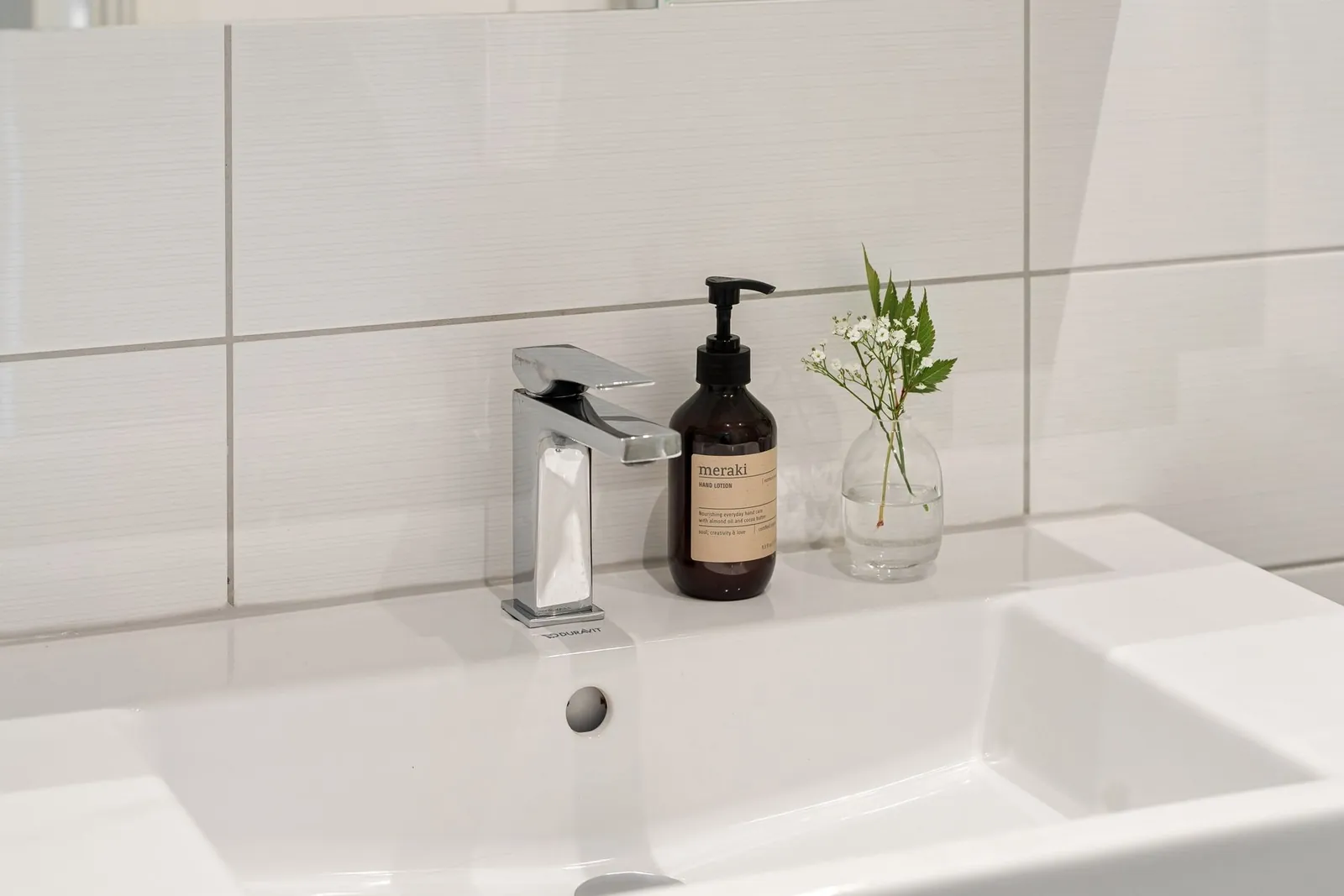 Satin and semi-gloss bathroom paint cans with brush and roller on a drop cloth