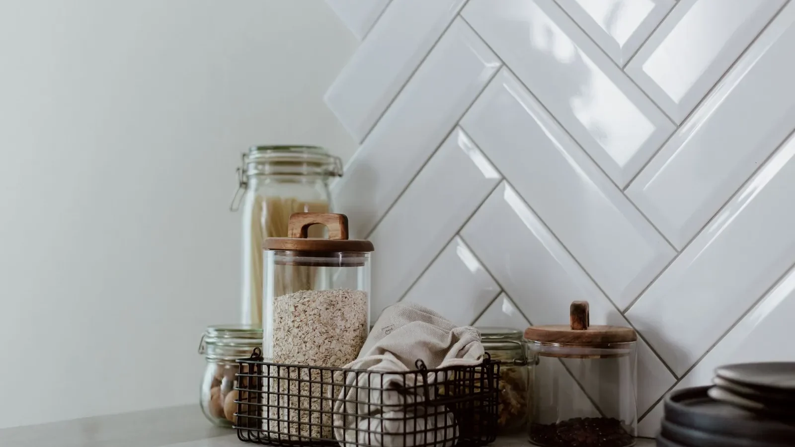 Clear airtight plastic containers with silicone gasket lids in 1-quart and 4-quart sizes stacked on a white pantry shelf