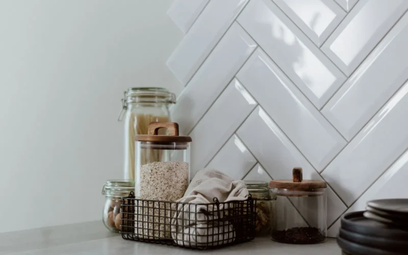 Clear airtight plastic containers with silicone gasket lids in 1-quart and 4-quart sizes stacked on a white pantry shelf