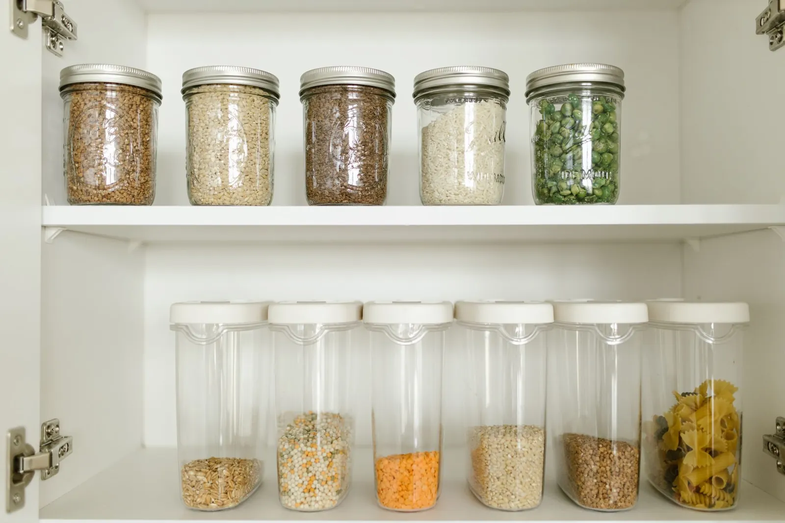 Clear airtight plastic containers with silicone gasket lids in 1-quart and 4-quart sizes stacked on a white pantry shelf