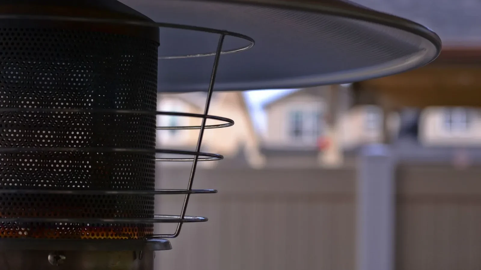 Three types of patio heaters arranged on a small deck: a tabletop propane heater on a side table, a wall-mounted electric heater on the pergola, and a tall pyramid propane heater in the corner
