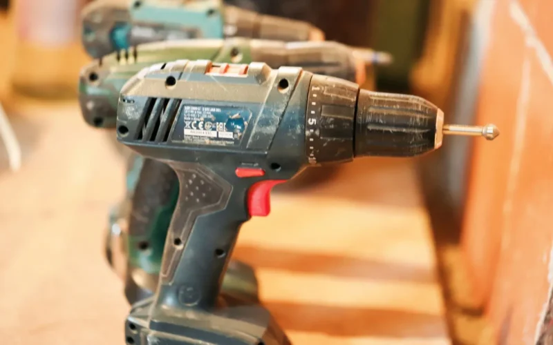 Cordless drill with 4.0 Ah battery pack beside a corded drill with coiled power cord on a workbench