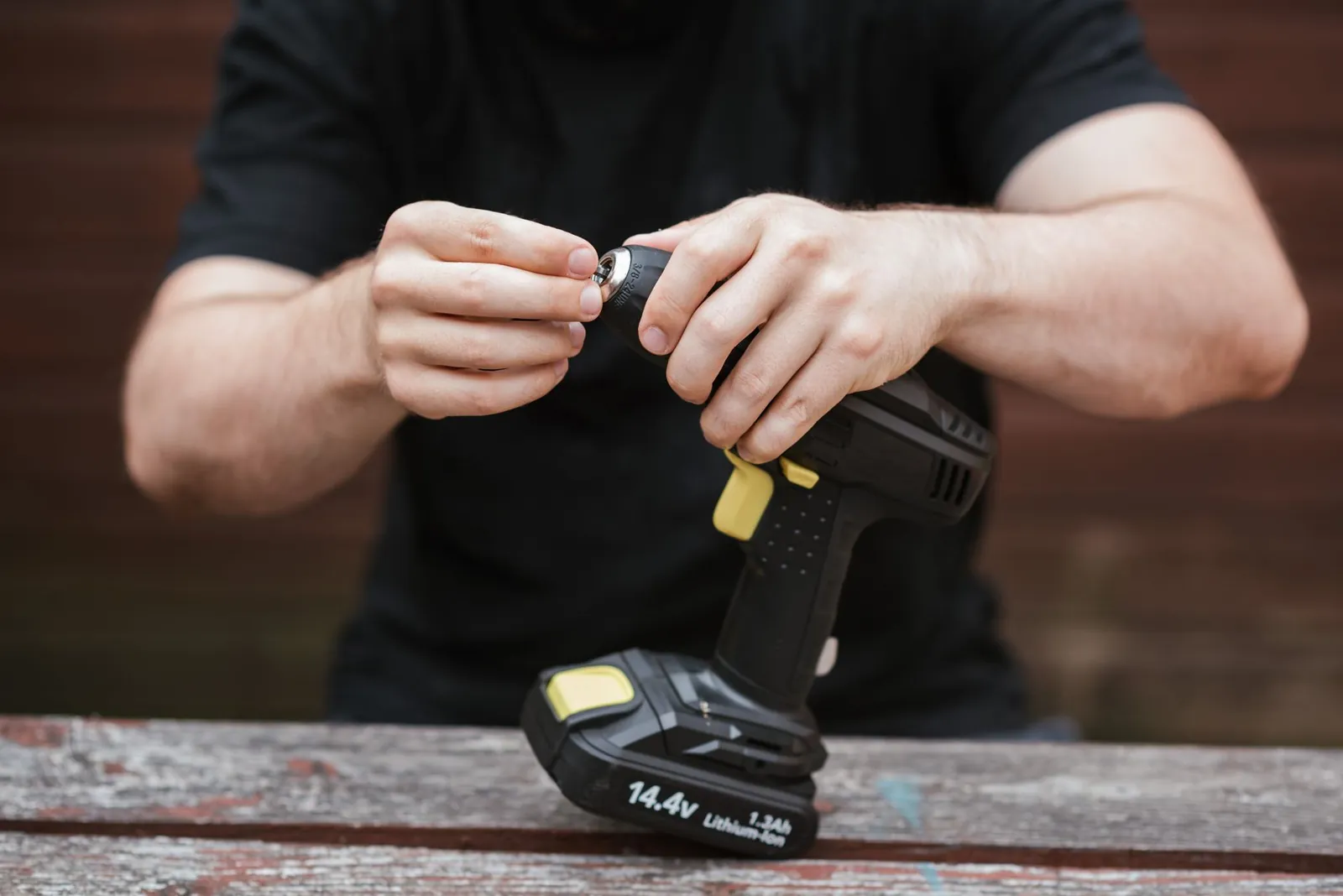 Cordless drill with 4.0 Ah battery pack beside a corded drill with coiled power cord on a workbench