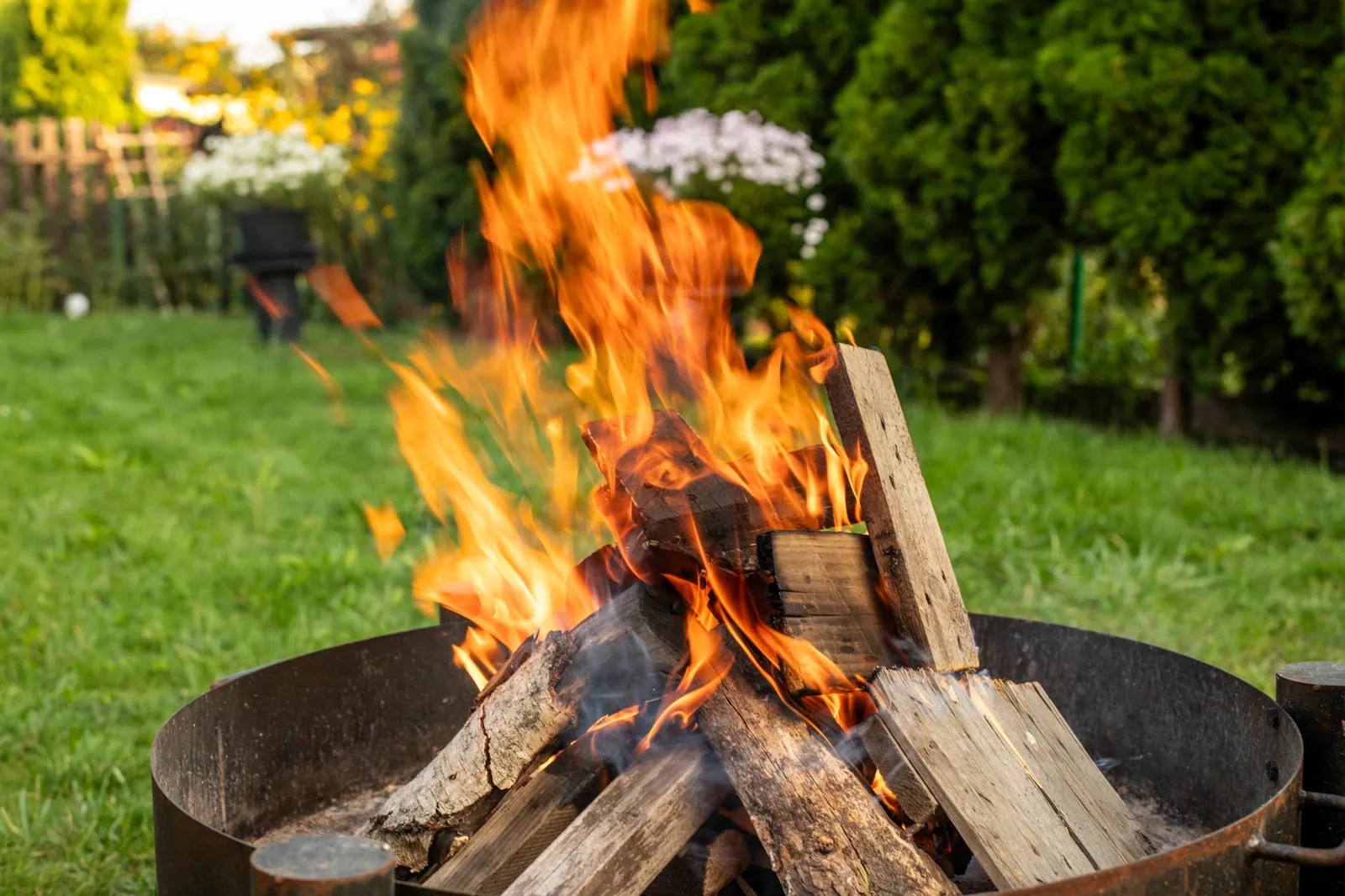 Dry-stacked granite pavers forming the second course of a fire pit ring, with a bubble level resting across two stones and a gravel base visible below