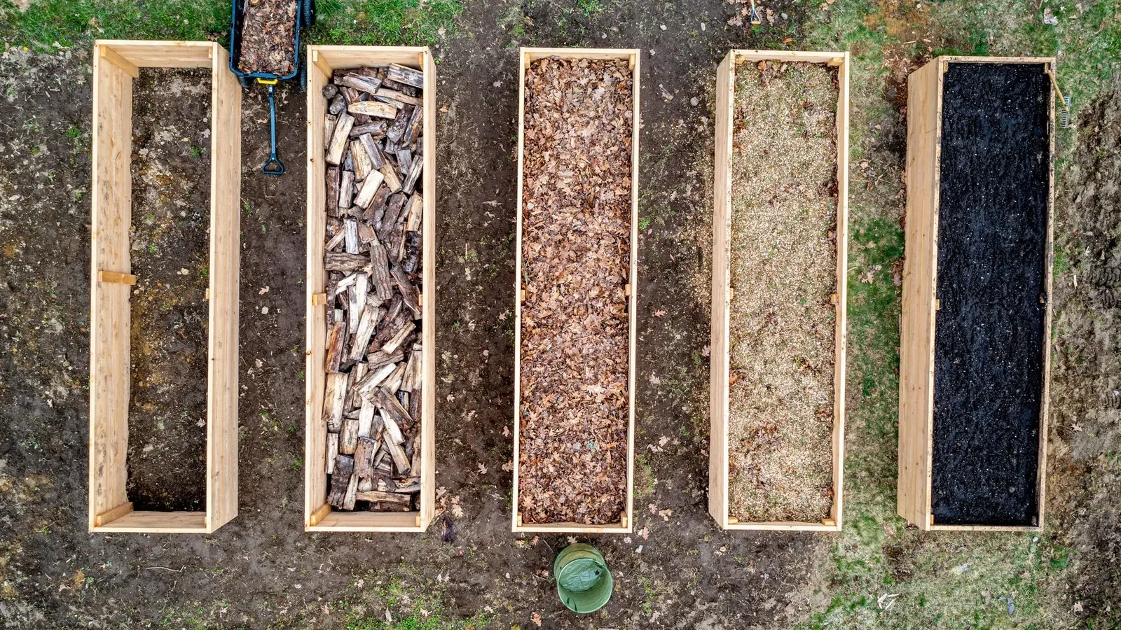 Cedar raised garden bed frame assembled on level ground with a power drill and exterior screws beside it