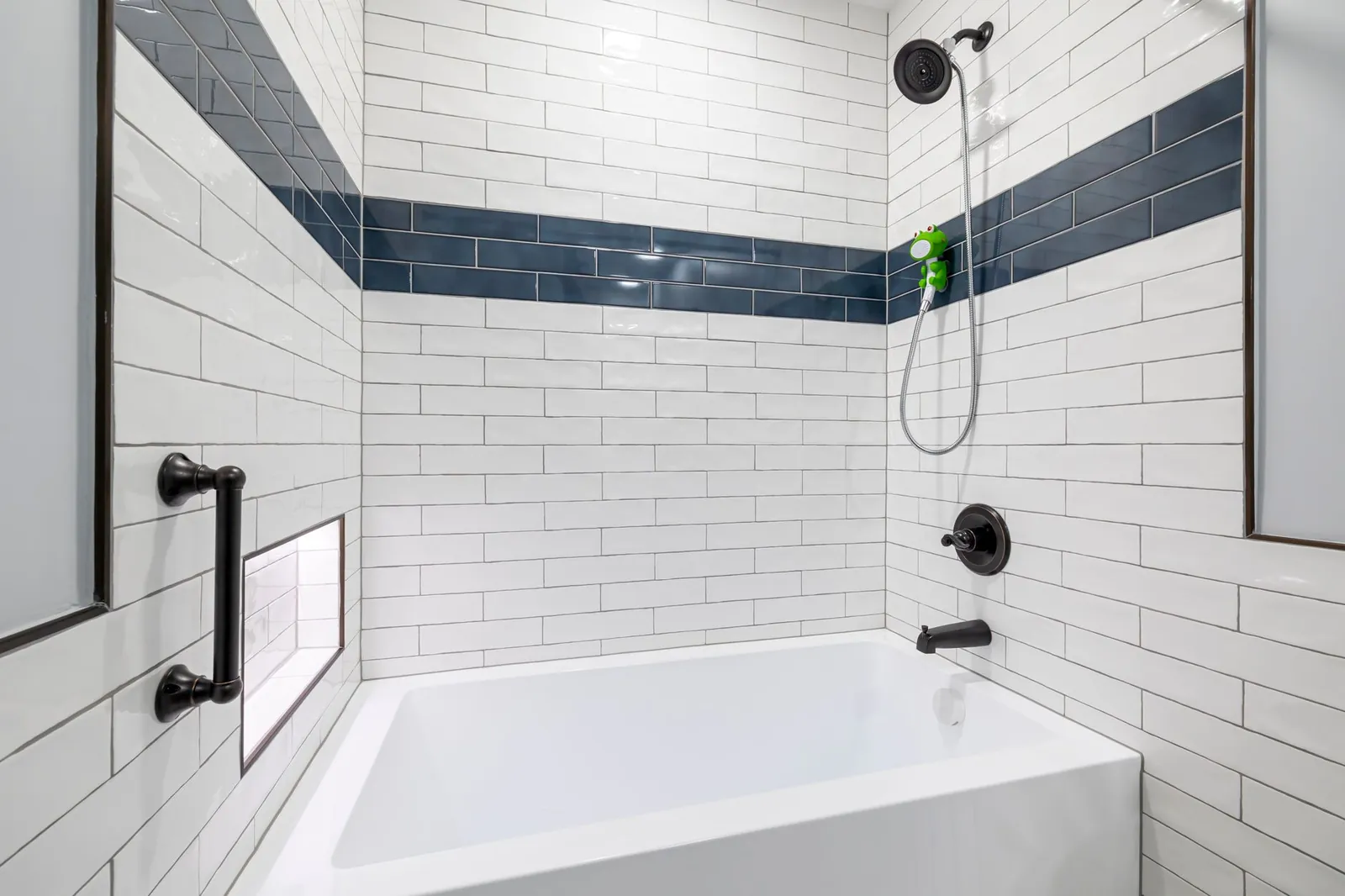 Wet sponge smoothing a fresh caulk bead along the edge of a bathtub surround