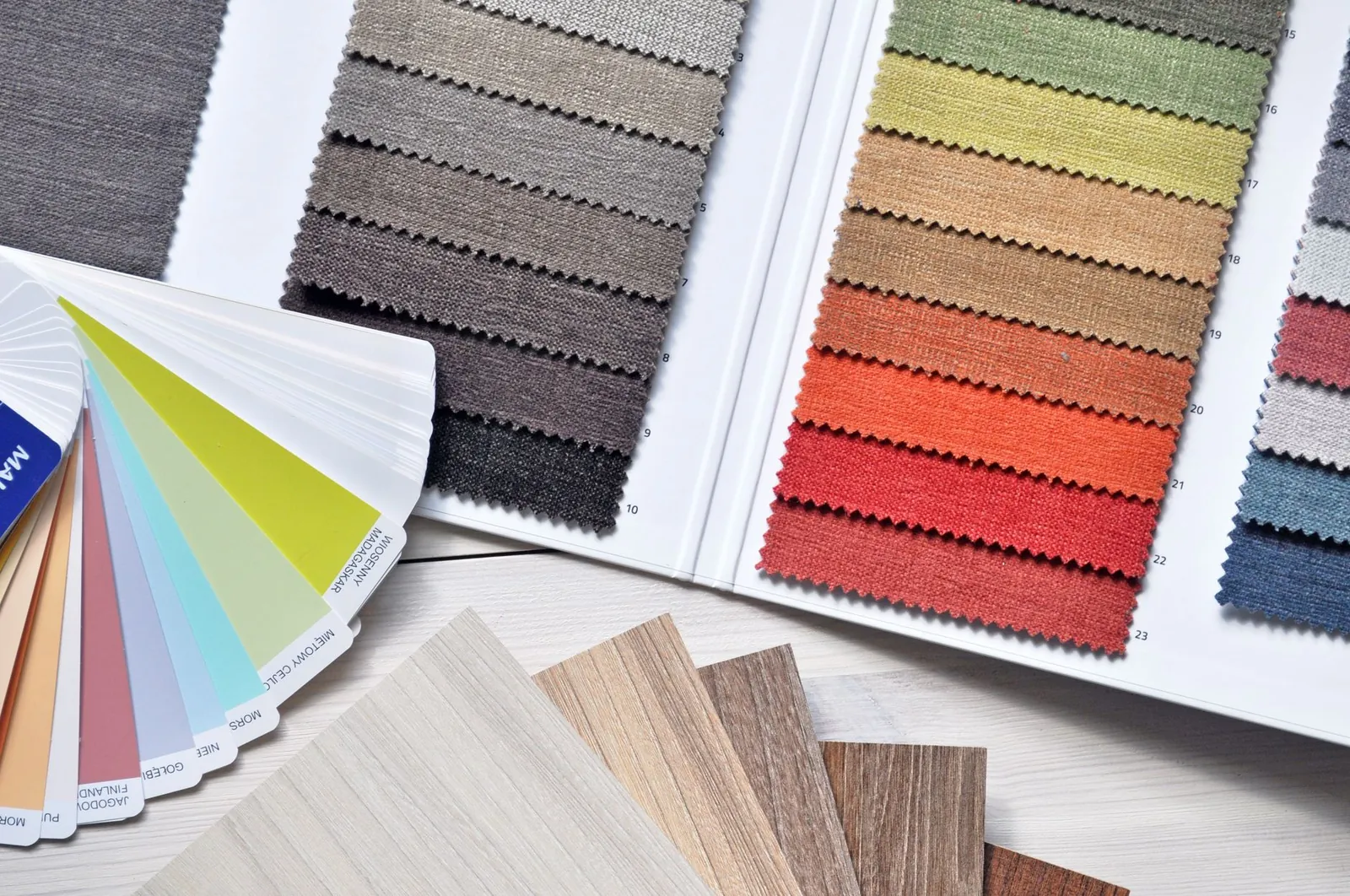 Afternoon sunlight crossing a wall showing two large paint sample swatches in warm white and soft gray, demonstrating how light shifts color