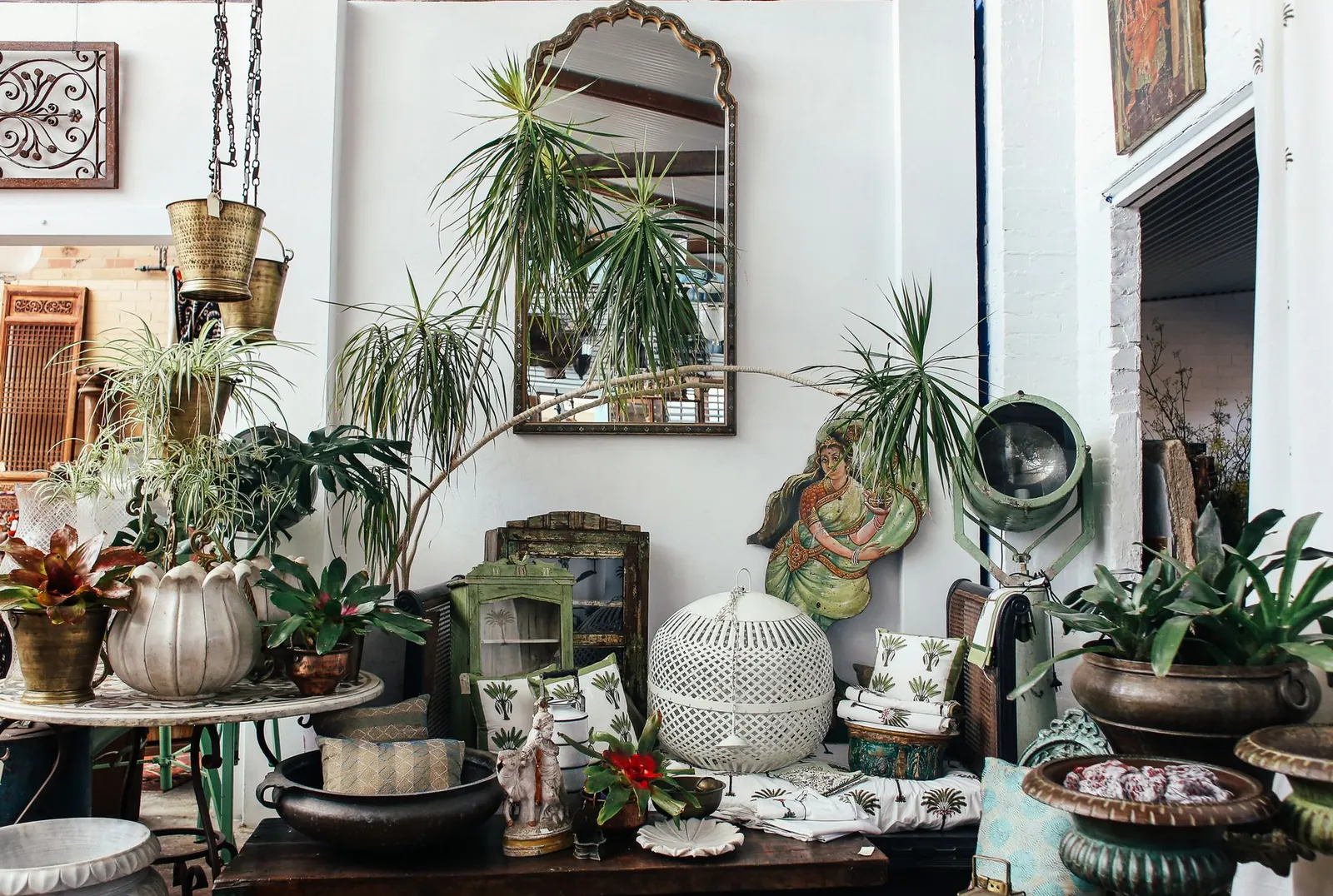 Close-up of a styled bookshelf combining ceramic vessels, woven baskets, and leather-bound books in a cohesive earthy palette