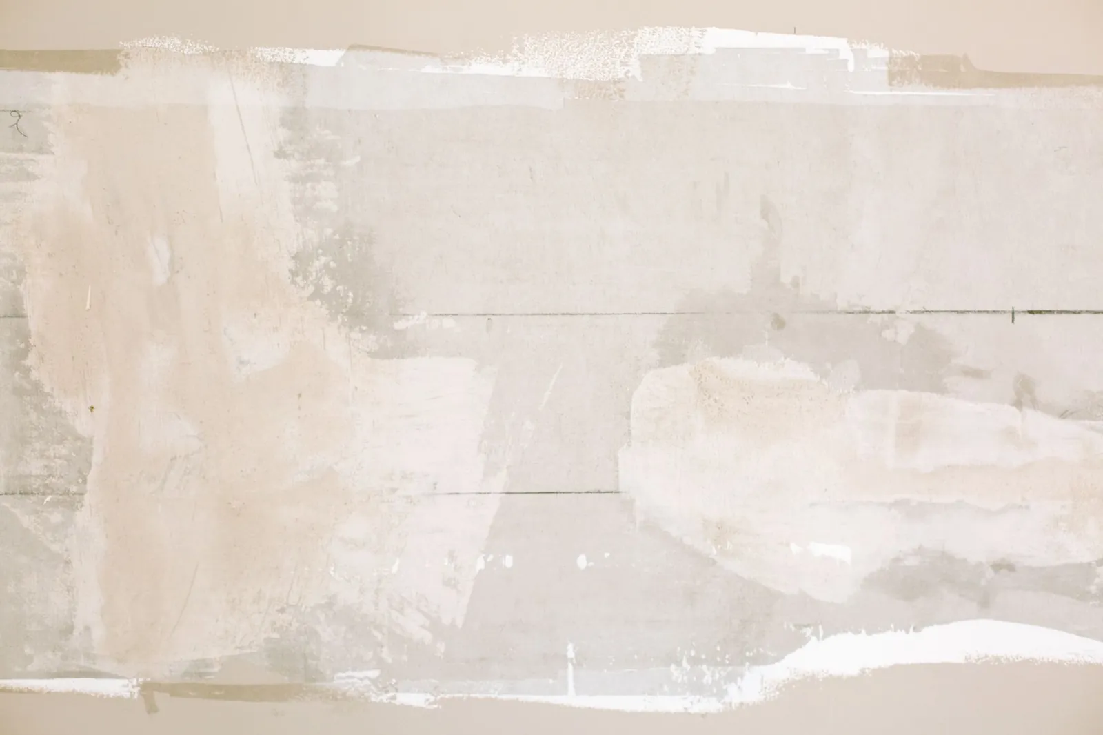 Self-adhesive drywall patch pressed over a medium-sized hole before the first coat of joint compound is applied
