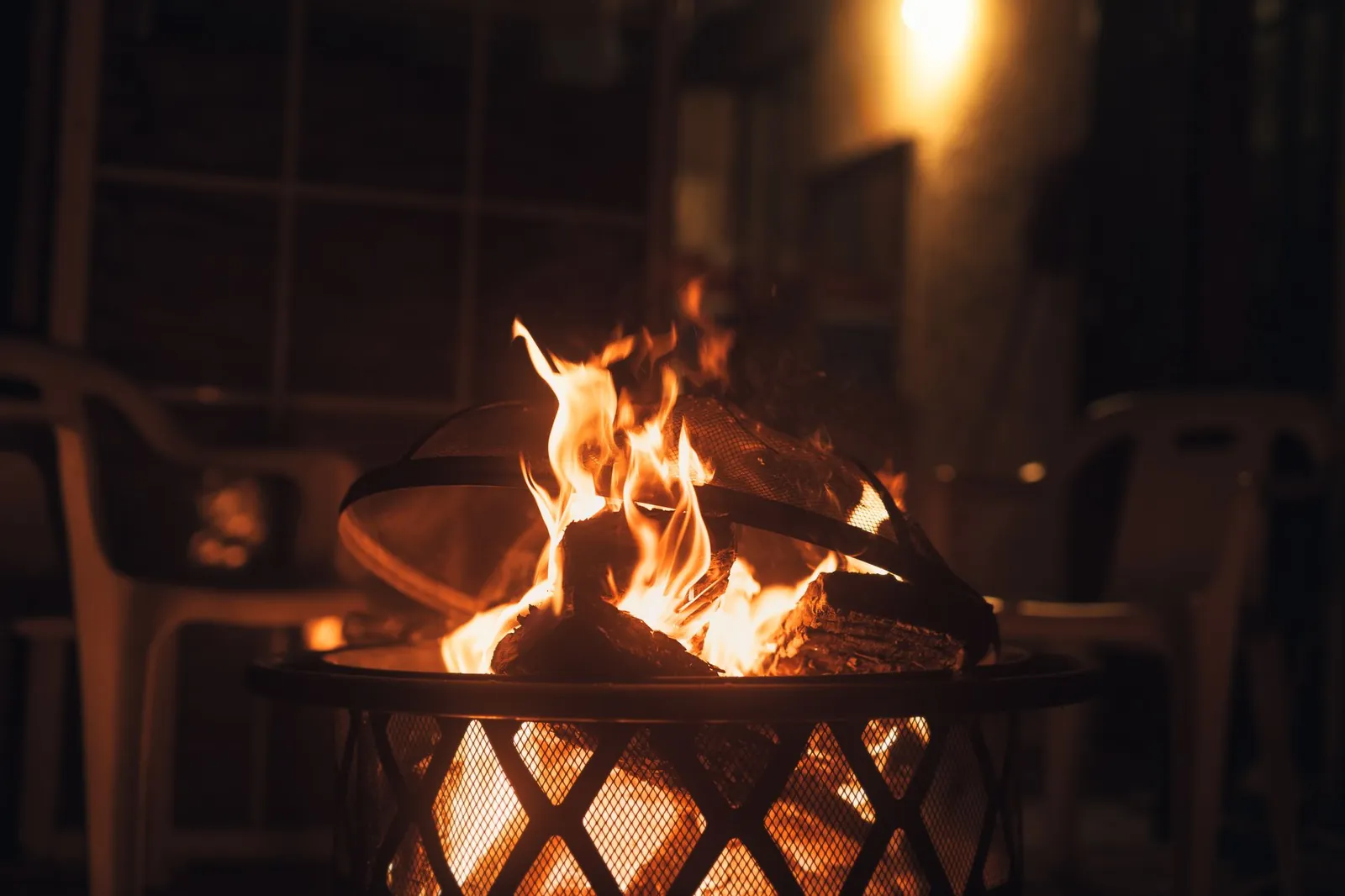 Propane patio heater standing on a concrete patio beside cushioned chairs on a cool evening