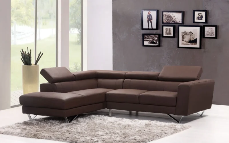 A standard three-seat sofa against the wall of a compact living room, with a narrow side table and floor lamp showing the clearance around it