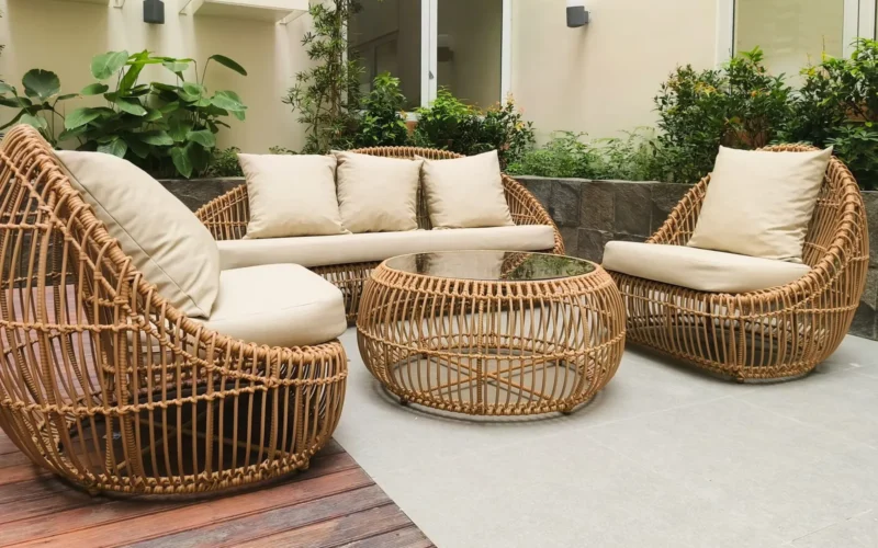 Composite decking boards in charcoal gray installed on a backyard patio, showing realistic wood-grain texture up close