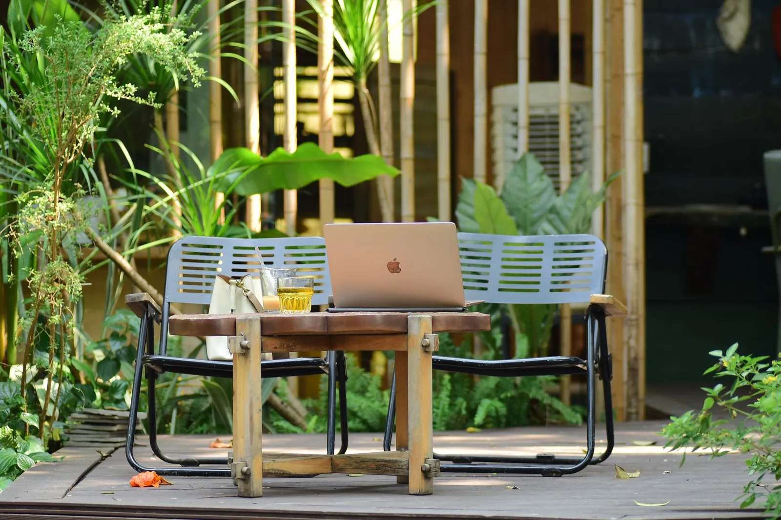 Composite decking boards in charcoal gray installed on a backyard patio, showing realistic wood-grain texture up close